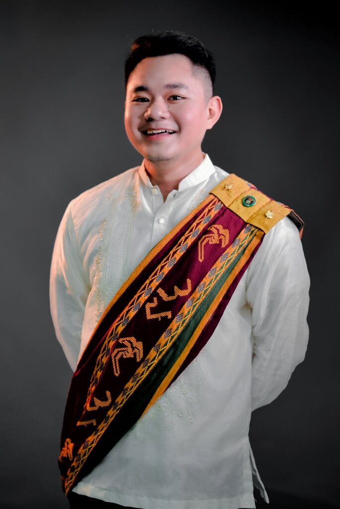 An image of Asst. Prof. Durian in formal wear with a Sablay.